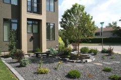 borders - small rundle boulder retaining wall with 22 mm limestone and black mulch beds with assorted shrubs and perennials