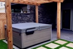cozy hot tub area with paving stone stepping stones and artificial turf