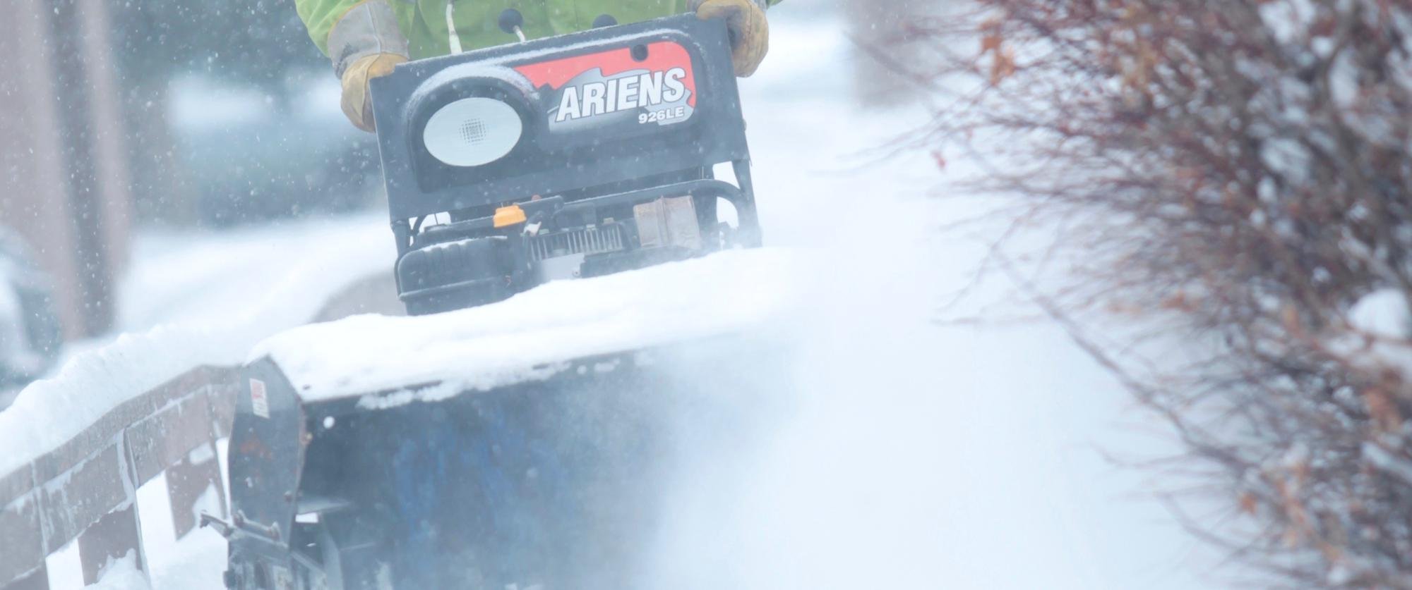 Clearing residential sidewalks with a snow blower