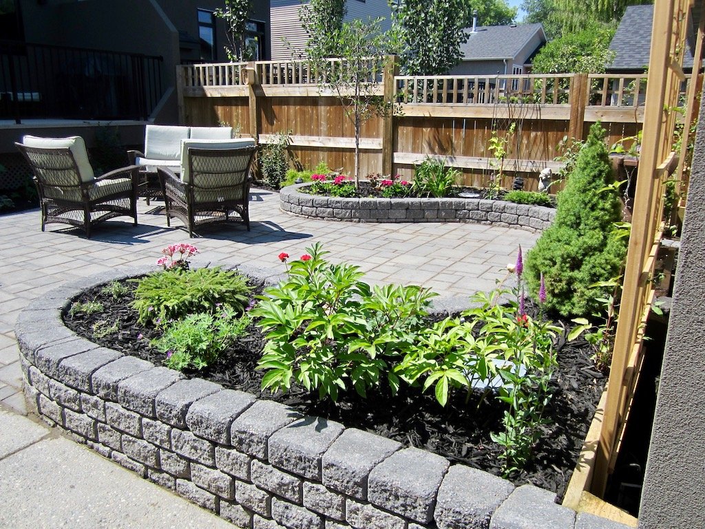 Planting in raised stone garden beds in a private backyard