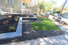 borders - onyx black raised bed with piedemonte capstones coping shale grey with black mulch beds and mow brick border with 20 mm rundle rock