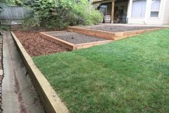 borders - pressure treated retaining wall and raised beds with cedar mulch and garden mix