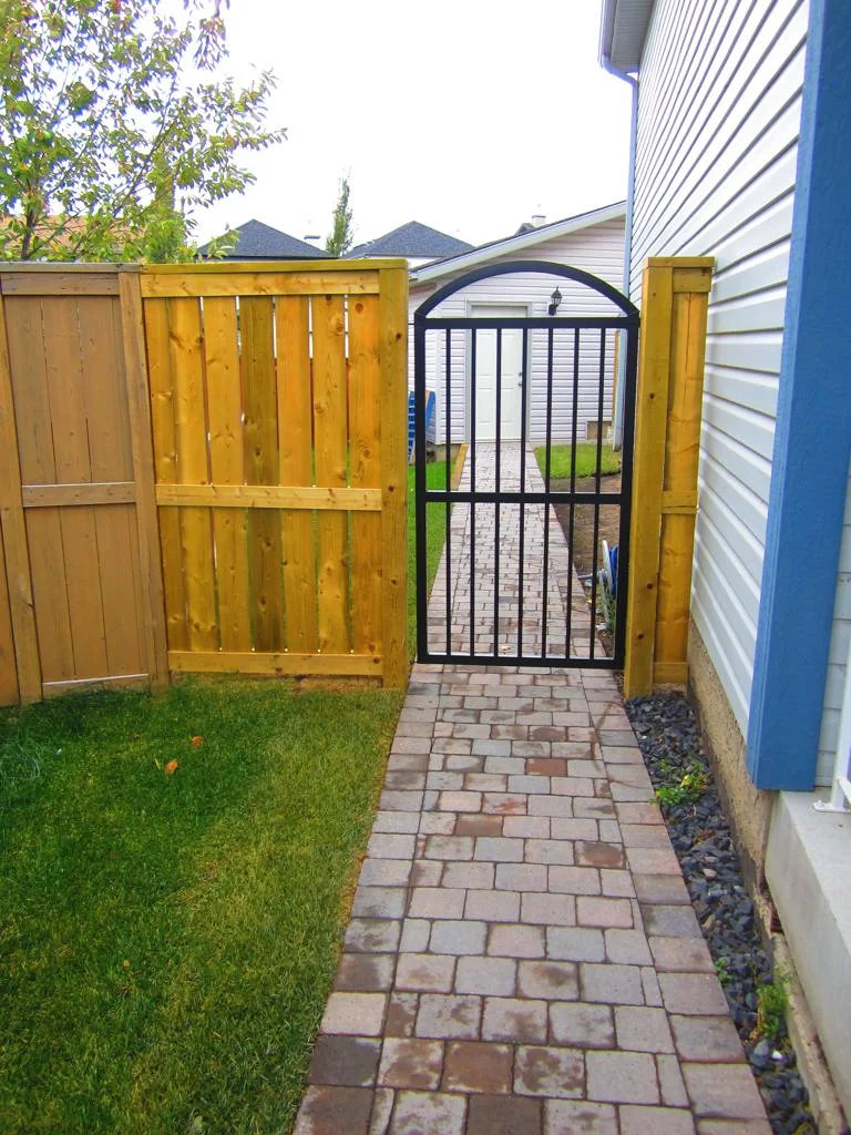 Gates - pressure treated fortress style fence with decorative iron gate