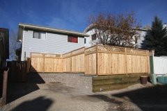 Fences - Cedar fence with decorative lattice top built on a combination of rustic pisa and capstone and 6 foot x 6 foot pressure treated retaining walls
