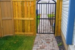 Gates - pressure treated fortress style fence with decorative iron gate