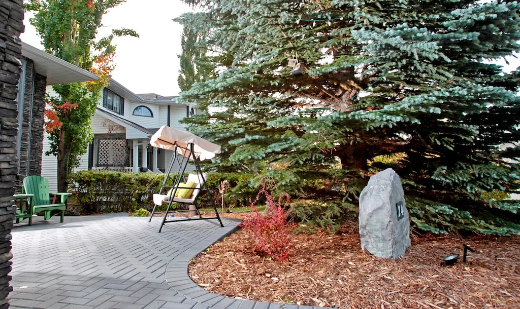 Paving stone patio with cedar mulch and a decorative address boulder