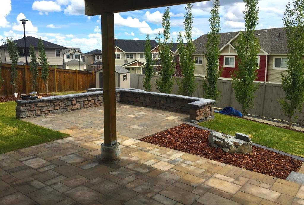 Patio - River rock paving stone in toscana with belvedere wall in copper canyon with dimensional coping in pacific grey