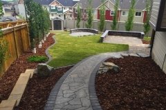 barkman flagstone in sierra grey with a cobble charcoal border with decorative Kendal boulders
