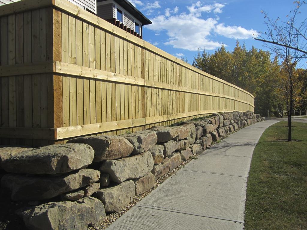 retaining wall - sandstone slab retaining wall with pressure treated fortress style fence