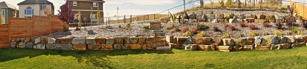 retaining wall - tiered stackable ironstone retaining wall with foothills alpine mulch beds and assorted perennials