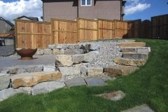retaining wall - stackable ironstone slab retaining wall and steps with charcoal holland pavers and washed gravel beds
