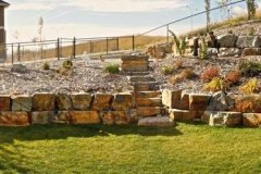 retaining wall - tiered stackable ironstone retaining wall with foothills alpine mulch beds and assorted perennials