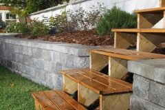 Wooden steps integrated into stone retaining wall